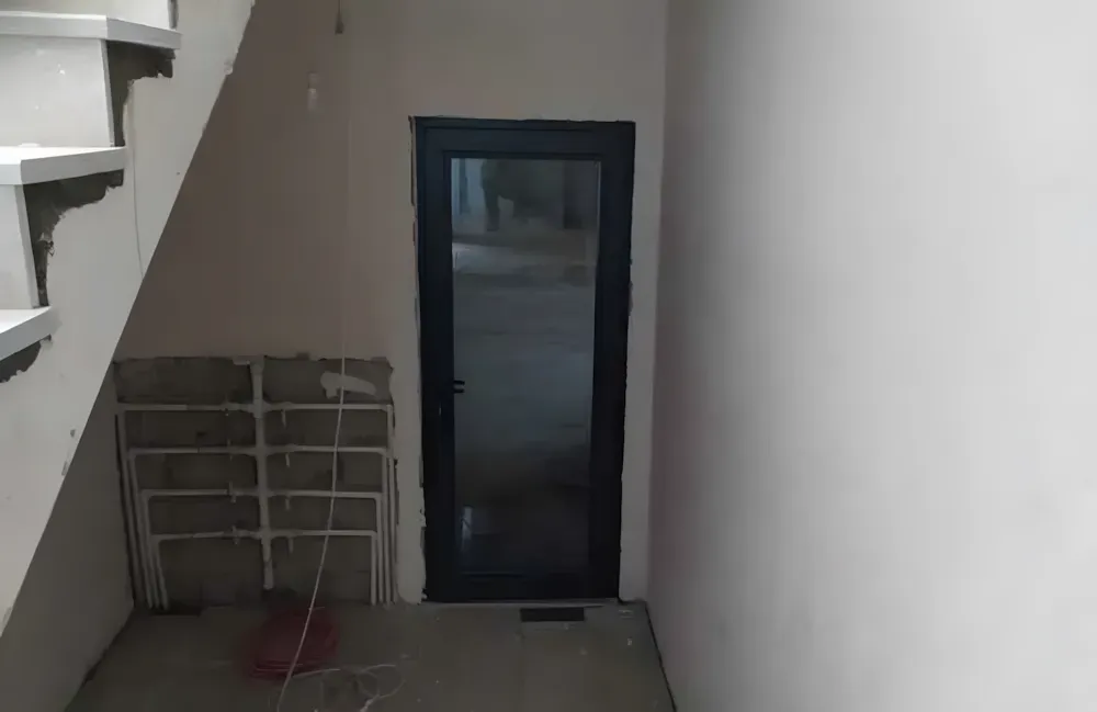 Kocaeli PEN tarafından montajı yapılmış, antrasit renkli, füme camlı, modern ve çift kanatlı kartepe alüminyum kapı apartman giriş kapısı.