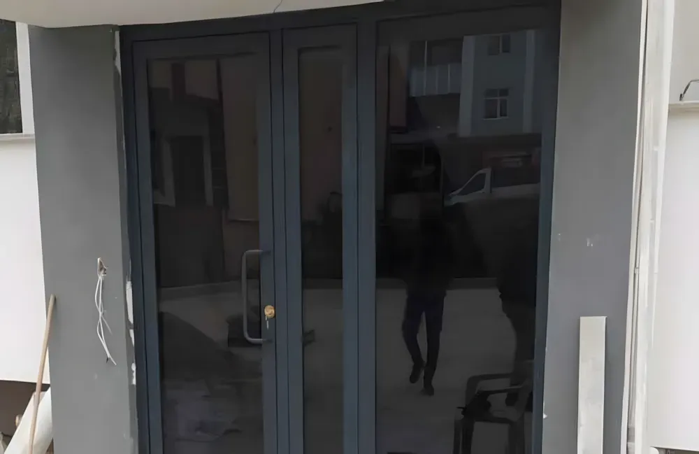 Kocaeli PEN tarafından montajı yapılmış, antrasit renkli, füme camlı, modern ve çift kanatlı kartepe alüminyum kapı apartman giriş kapısı.