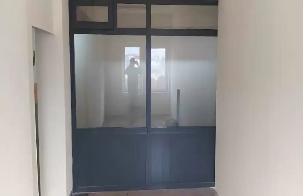 Kocaeli Körfez'de bir işletme için Kocaeli PEN tarafından yapılan, antrasit renkli, alt kısmı buzlu cam, üst kısmı şeffaf camlı, modern alüminyum ofis bölme sistemi.