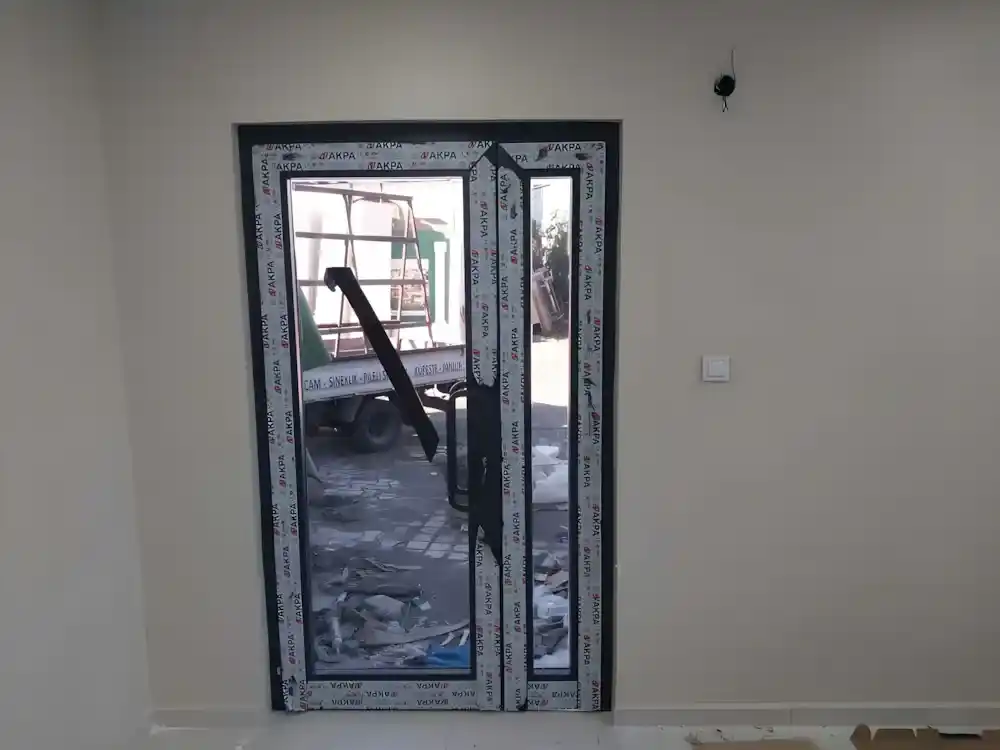 Suadiye Alüminyum Kapı Kocaeli PEN tarafından AKPA alüminyum profilleri kullanılarak montajı yeni tamamlanmış, antrasit renkli, çift kanatlı, modern bir alüminyum kapı.