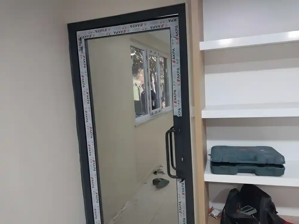 Suadiye Alüminyum Kapı Kocaeli PEN tarafından AKPA alüminyum profilleri kullanılarak montajı yeni tamamlanmış, antrasit renkli, çift kanatlı, modern bir alüminyum kapı.