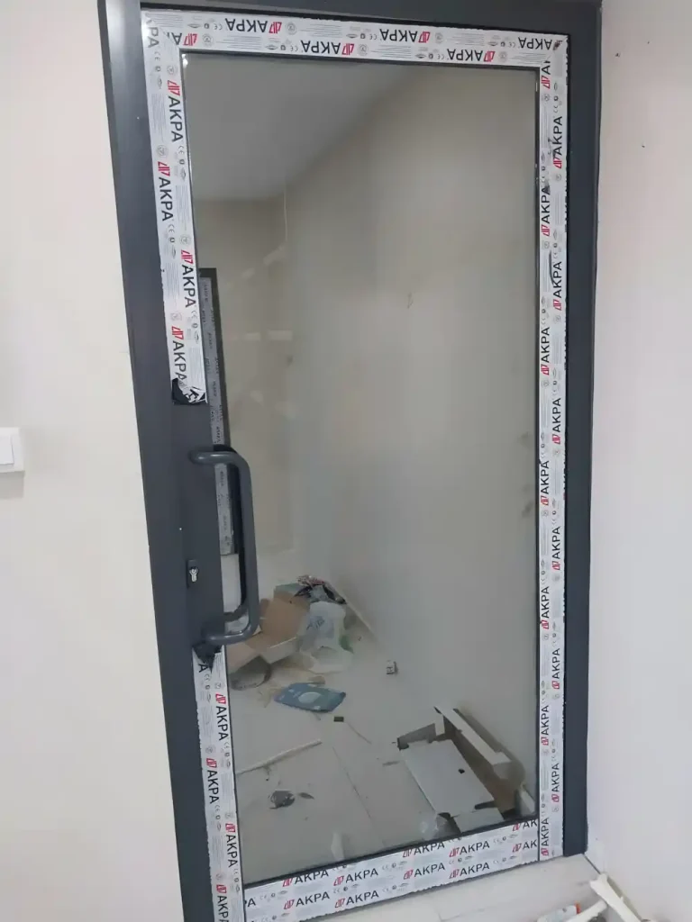 Suadiye Alüminyum Kapı Kocaeli PEN tarafından AKPA alüminyum profilleri kullanılarak montajı yeni tamamlanmış, antrasit renkli, çift kanatlı, modern bir alüminyum kapı.