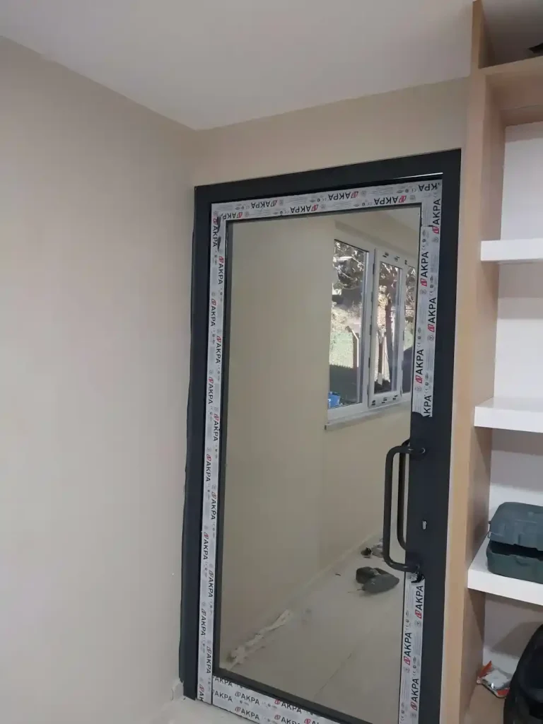 Suadiye Alüminyum Kapı Kocaeli PEN tarafından AKPA alüminyum profilleri kullanılarak montajı yeni tamamlanmış, antrasit renkli, çift kanatlı, modern bir alüminyum kapı.