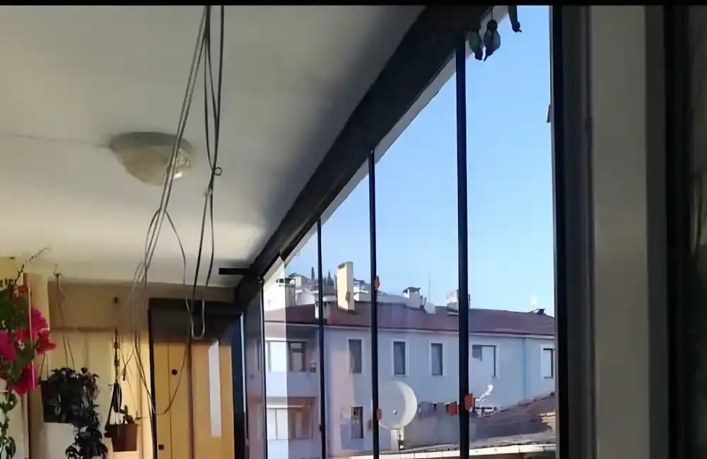 Kocaeli İzmit Merkez Cam Balkon. Kocaeli PEN tarafından montajı yapılmış, şeffaf temperli camlı, antrasit profilli, modern katlanır cam balkon.