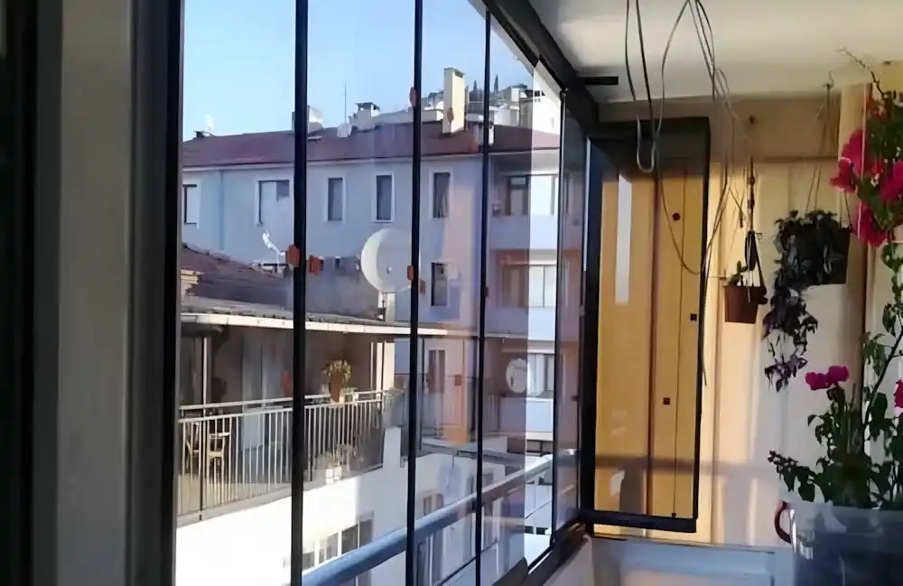 Kocaeli İzmit Merkez Cam Balkon. Kocaeli PEN tarafından montajı yapılmış, şeffaf temperli camlı, antrasit profilli, modern katlanır cam balkon.