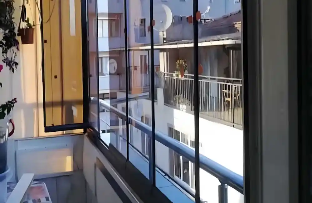 Kocaeli İzmit Merkez Cam Balkon. Kocaeli PEN tarafından montajı yapılmış, şeffaf temperli camlı, antrasit profilli, modern katlanır cam balkon.